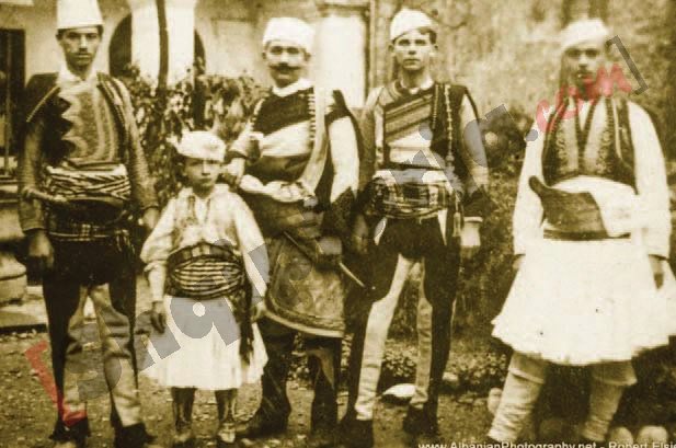 Një grup burrash shqiptarë në vitet 1900 me logo